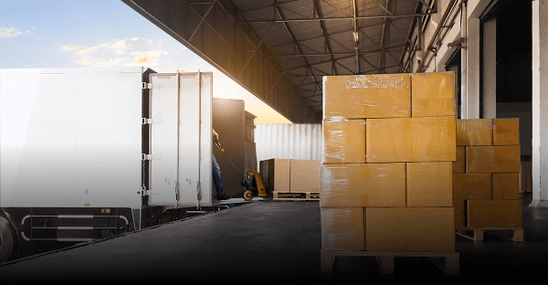 Warehouse loading dock with stacked cardboard boxes.