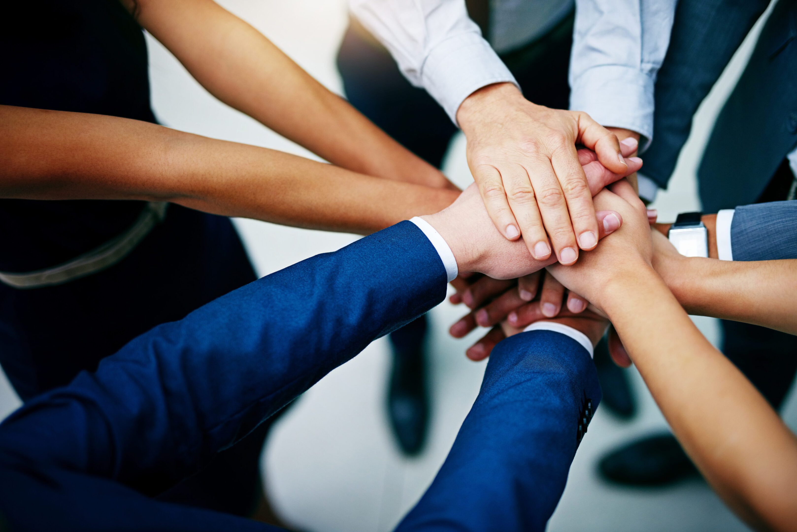 Teamwork symbolized by hands stacked together.
